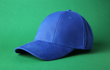 Poster - Stylish blue baseball cap on green background