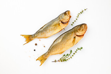 Cold smoked two sea fish carcass close up isolated on white background decorated with fresh sprig of thyme, crystals of coarse pink salt, black peppercorns. Salty snacks. Omega3