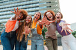 © Jose Calsina - Group of young adult women smiling and gesturing at camera together. Teenage females posing for a funny photo. Teen student girls with positive expression having fun. Feminine ladies laughing outside