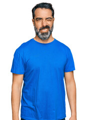 Sticker - Middle aged man with beard wearing casual blue t shirt winking looking at the camera with sexy expression, cheerful and happy face.