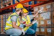 © chokniti - Warehouse worker logistic team wearing hard hat working in aisle between tall racks with packed goods warehouse for industry business of import, export delivery to global market, shipping management
