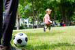 © krongthip - A boy runs and kicks football in the grass.