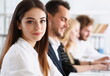 © H_Ko - Beautiful smiling woman portrait with group of people listen carefully during seminar. Study event client conversation job customer support service case hear in court leader performance concept