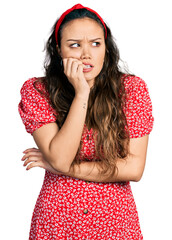 Sticker - Young hispanic girl wearing casual clothes looking stressed and nervous with hands on mouth biting nails. anxiety problem.