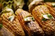Grilled sweet corn cobs with butter seasoned with cilantro closeup low angle view