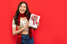 .Happy Smiling Asian Woman Holding Gift Box Over Red .Happy Smiling Asian Woman Holding Gift Box Over Red Background..