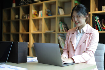 Happy businesswoman working with laptop in office.