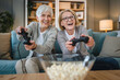 © Miljan Živković - Two senior women caucasian friends or sisters play console video game