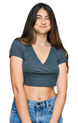 Sticker - Young beautiful teen girl wearing casual crop top t shirt puffing cheeks with funny face. mouth inflated with air, crazy expression.