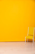 One yellow chair in orange wall interior