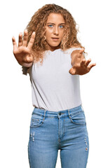 Poster - Beautiful caucasian teenager girl wearing casual white tshirt doing stop gesture with hands palms, angry and frustration expression