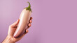 © Aris - Hand holding eggplant vegetable isolated on pastel background