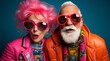 A Vibrant Elderly Couple with Pink Hair and Glasses on a Fun Colourful Background. A man and a woman with pink hair and glasses