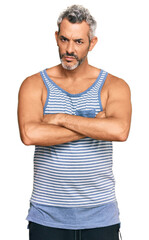 Canvas Print - Middle age grey-haired man wearing casual style with sleeveless shirt skeptic and nervous, disapproving expression on face with crossed arms. negative person.