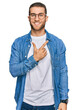 © Krakenimages.com - Young caucasian man wearing casual clothes cheerful with a smile on face pointing with hand and finger up to the side with happy and natural expression