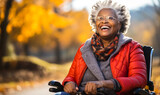 Fototapeta  - Joyful elderly African American woman with gray hair enjoying the autumnal park from her wheelchair, showcasing independence and positivity