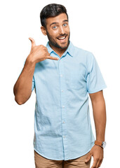 Sticker - Handsome hispanic man wearing casual clothes smiling doing phone gesture with hand and fingers like talking on the telephone. communicating concepts.