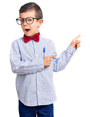 Poster - Cute blond kid wearing nerd bow tie and glasses smiling and looking at the camera pointing with two hands and fingers to the side.