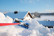 remove a lot of snow from the roof window with the snow shovel. sunny blue sky