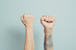 Two fists raised against a blue background. Concept of strength and unity.