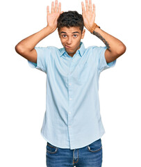 Sticker - Young handsome african american man wearing casual clothes doing bunny ears gesture with hands palms looking cynical and skeptical. easter rabbit concept.