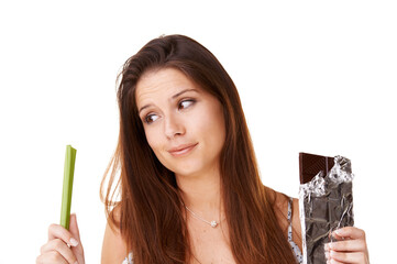 Decision, celery and chocolate with woman, choice and girl isolated on a white studio background. Nutrition, person and model with candy, vegan or diet plan with health, wellness and sweet with doubt