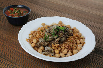 Wall Mural - Chicken liver noodles with chickpea, tomato and chilli sauce served in dish isolated on table side view of arabic food