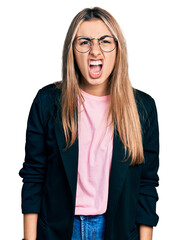 Sticker - Hispanic young woman wearing business jacket and glasses angry and mad screaming frustrated and furious, shouting with anger. rage and aggressive concept.