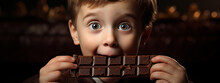 Close-up Portrait Of A Boy Eating Chocolate. The Harm Of Sweets For The Teeth.