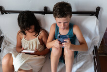 Siblings Watching Cartoon Cellphone At Home