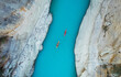 © ADDICTIVE STOCK - High angle view of unrecognizable people kayaking on blue narrow river flowing between rocky mountains during vacation at daytime