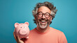 Man smiling broadly, and holding a piggybank, signifying responsible financial planning and savings.