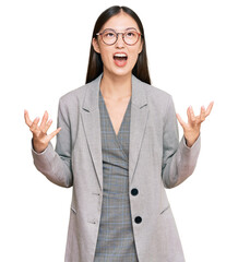 Sticker - Young chinese woman wearing business clothes crazy and mad shouting and yelling with aggressive expression and arms raised. frustration concept.