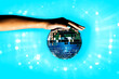 © ADDICTIVE STOCK - Woman holding disco ball against illuminated background