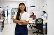 © ADDICTIVE STOCK - Smiling businesswoman with arms crossed in office