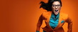 © aninna - stylish businesswoman in a suit and glasses running to success, orange banner with copy space