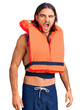 Young handsome man wearing nautical lifejacket winking looking at the camera with sexy expression, cheerful and happy face.
