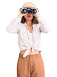 © Krakenimages.com - Young beautiful chinese girl wearing explorer hat holding binoculars thinking attitude and sober expression looking self confident