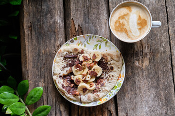 Sticker - Homemade flatbread with chocolate and bananas on a wooden background.