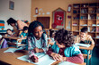 © Marko Geber - School children in classroom writing notes during class