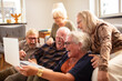 © Davor - Diverse senior people sitting at home laughing with laptop