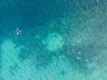 Aerial View Of A Person Floating In Clear Azure Waters