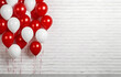 © Bonsales - Group of red and white inflatable balloons on white brick wall background with copyspace. Interior of room for children or wedding party indoor.