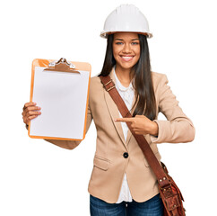 Sticker - Beautiful hispanic woman architect showing black space on clipboard smiling happy pointing with hand and finger