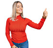 © Krakenimages.com - Beautiful blonde woman wearing casual clothes looking proud, smiling doing thumbs up gesture to the side