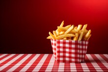 Crispy Golden Fries Served In A Red Basket On A Checkered Tablecloth With Copyspace For Text.