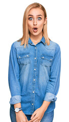 Wall Mural - Beautiful caucasian woman wearing casual denim jacket afraid and shocked with surprise expression, fear and excited face.