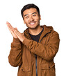 Young Chinese man in studio background feeling energetic and comfortable, rubbing hands confident.