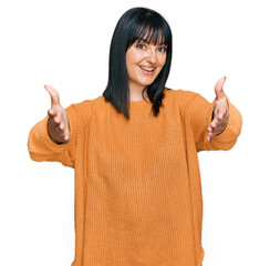 Canvas Print - Young hispanic woman wearing casual clothes looking at the camera smiling with open arms for hug. cheerful expression embracing happiness.