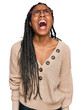 © Krakenimages.com - African american woman wearing casual clothes angry and mad screaming frustrated and furious, shouting with anger. rage and aggressive concept.